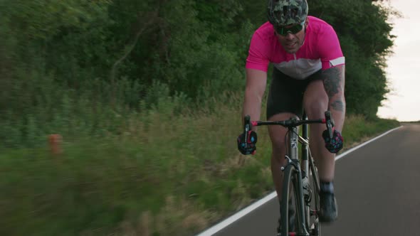 Tracking shot of a male cyclist on country road.  Fully released for commercial use.