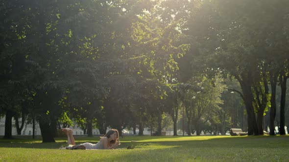 Woman in park watching online TV alt