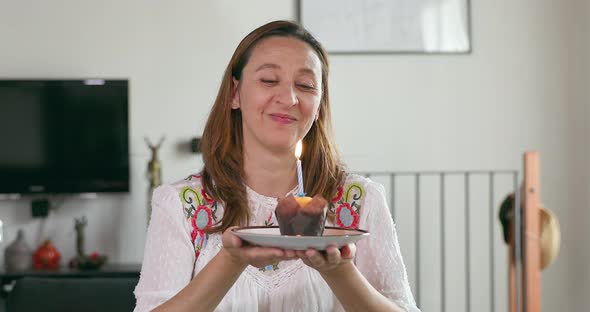 Woman blowing birthday candle