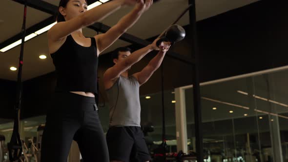 Man and woman exercise with kettlebell alt