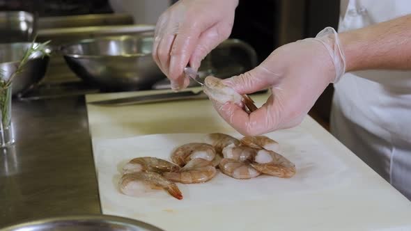 Closeup of a Chef Cutting a Shrimp with a Knife in the Restaurant Kitchen alt