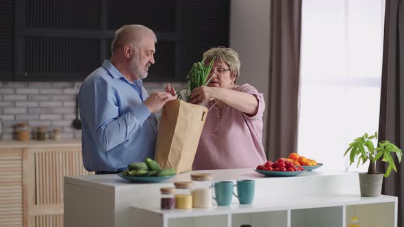 Aged Woman is Unpacking Bag with Food Her Husband Bought Greenery and Bread in Market Old Spouses alt