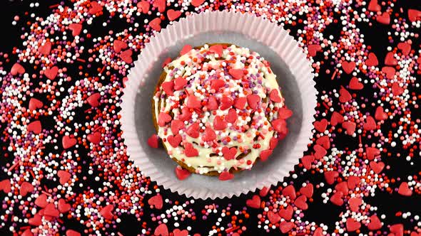 Shortbread with white chocolate icing in a paper form for packaging is on a black table.