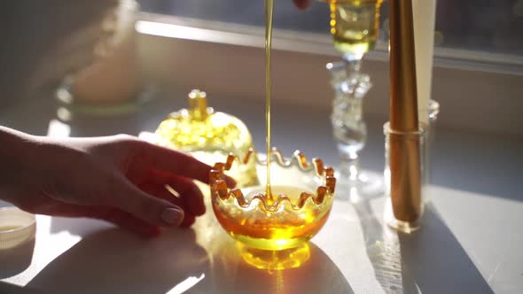 WOman Pouring Honey in Glass Bowl alt