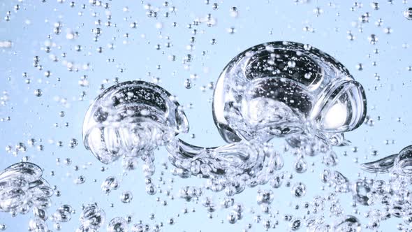 Super Slow Motion Shot of Moving Gel Bubbles in Water on Light Blue Background at 1000Fps. alt