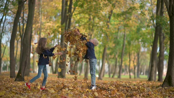 Boy and Girl Throw and Play a Fallen Leaf Slow Motion