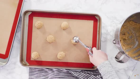 Flat lay. Step by step. Scooping peanut butter cookies dough with dough scooper into the baking  alt