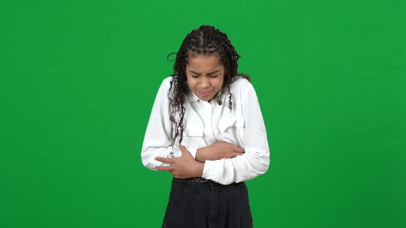 Upset Teen African American Girl Suffering Stomach Ache on Green Screen alt
