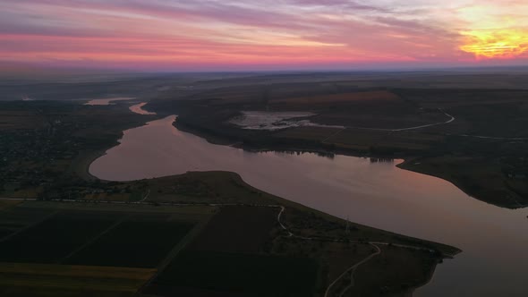 Aerial drone view of the Duruitoarea natural reservation at sunset in Moldova. River and village, hi alt