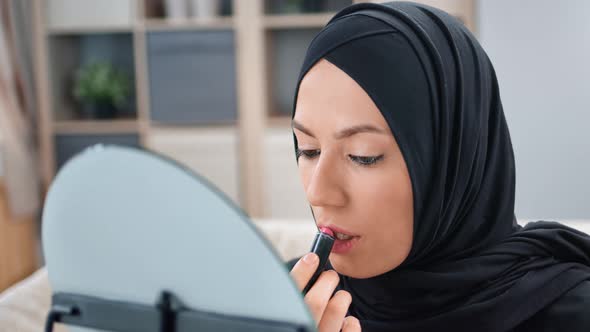 Closeup Arabic Woman in Black Hijab Applying Lipstick in Front of Mirror Use Moisturizer Lip Gloss alt