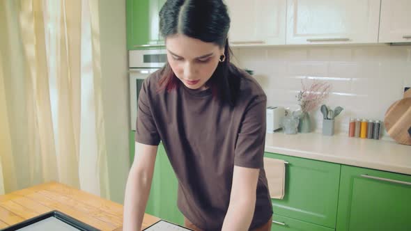 Young Caucasian Woman in Brown Tshirt Cooking at Home Kitchen