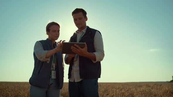 Two Farmers Work Tablet Computer in Golden Sunlight alt