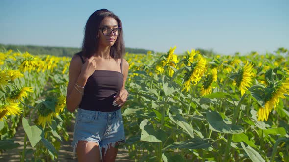 Lovely Female Farmer Eximining Plant in Field alt