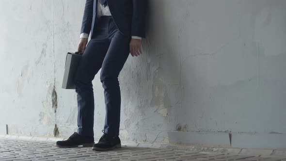 Fired Depressed Man in Covid-19 Face Mask Sitting Down in Urban Underground Crossing. Portrait of alt