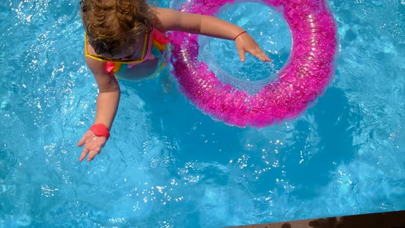 A Child Swims in a Pool with a Circle alt