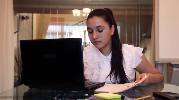Business Girl is Experiencing Joy Throwing Documents Up in the Office While Sitting at the Table alt