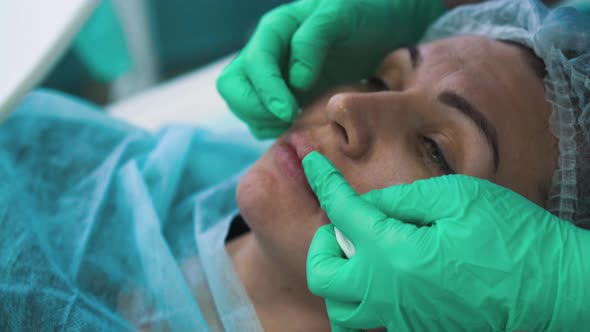 Lady Talks with Cosmetologist at Lips Augmentation Procedure alt