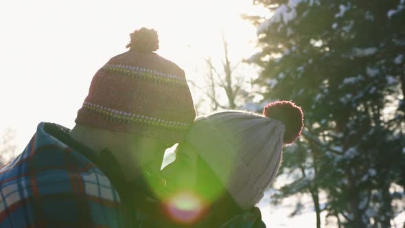 Girl and Guy in the Embrace of a Sunny Day Winter Forest Sunlight Flareclose Up alt