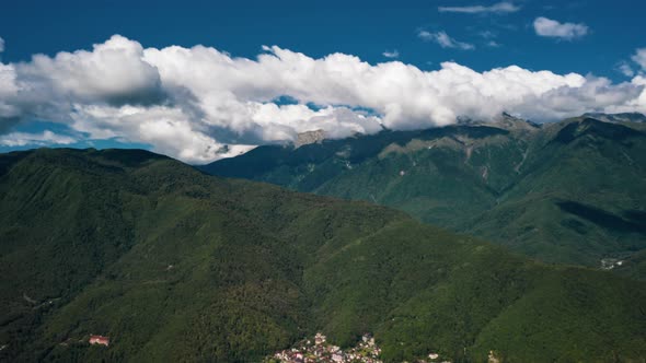Time-lapse of sky over Caucasus mountains and valleys, moving clouds in sunny summer day