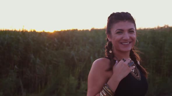 Smiling Young Hippie Woman with Boho Accessories Relaxing in Nature alt