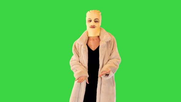 Girl in Fur Coat Dancing Slightly Adjusting Her Balaclava on a Green Screen Chroma Key