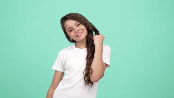 Kid Touch Her Long Curly Beautiful Hair with Smiling Face and Posing for Photo Fashion Model