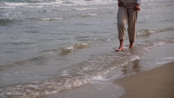 Closeup of a woman strolling on the beach by the sea