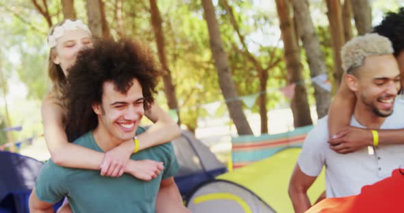 Couples in piggyback ride having fun at music festival alt