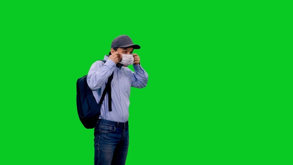 A Man Pedestrian Puts on Protective Mask During COVID-19 Pandemic on Green Screen