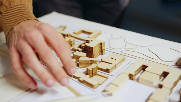 Close Up of Architect Hand Checking City Model Concept alt