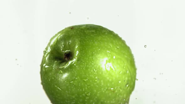Flying of Green Apple in White Kitchen Background in Slow Motion alt