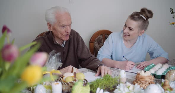 Grandfather and Granddaughter Writing Easter Cards Greetings To Loving Family. alt