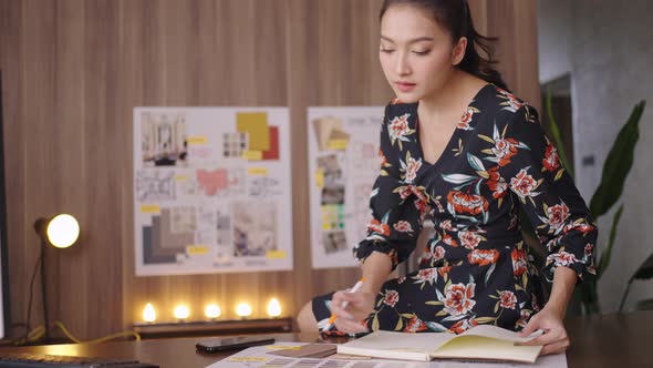 Stylish Asian business woman designer working with color swatch alt