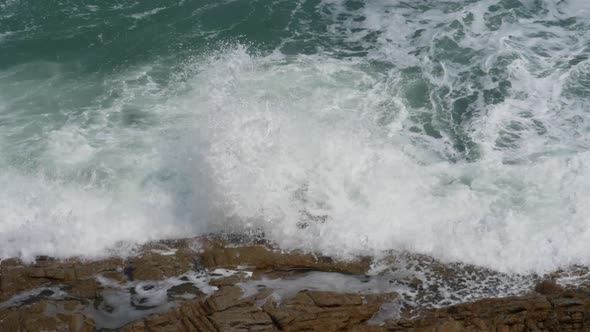 Waves Splashing on Rocks in Sunny Windy Day