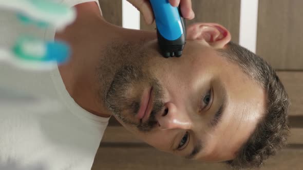 Vertical Video of Man Shaves His Cheek