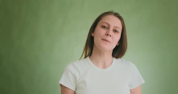 Attractive Woman with Blonde Hair Poses for Camera on Green alt