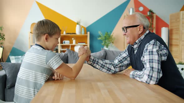 Caring Grandfather Teaching Boy To Wrestle Having Fun Doing Sports at Home alt