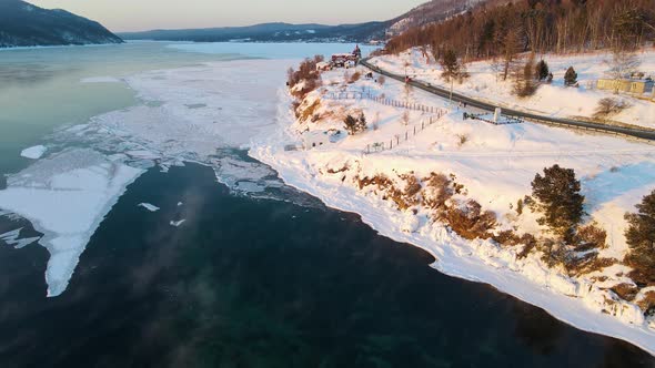 Highway to the northern mountain village on the bank of ice-free river. Slow-motion alt