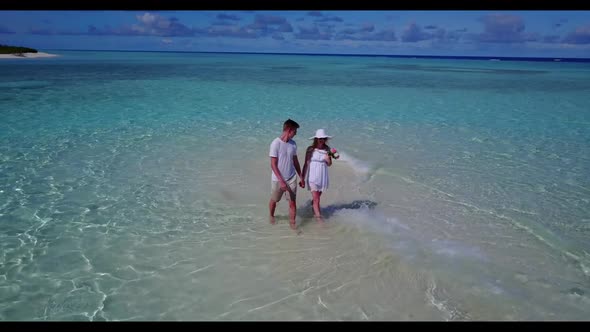 Two people happy together on perfect lagoon beach wildlife by aqua blue sea with bright sand backgro alt