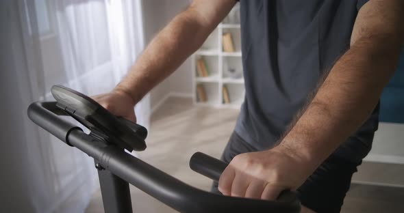 Middleaged Man Is Training on Exercise Bicycle at Home Healthy Lifestyle Keeping Physical Condition alt