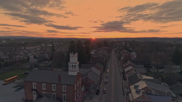 Drone View of a Small Town and a Steeple at Sunrise as it gets Ready to Break the Horizon, with Oran alt
