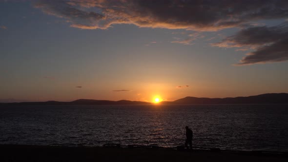 Person Walking In Front Of Sunset On Fidalgo Island Anarcortes Washington alt