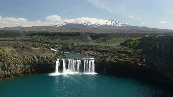 Beautiful Thjofafoss Waterfall with Hekla Mountain Covered By Snow on the Background