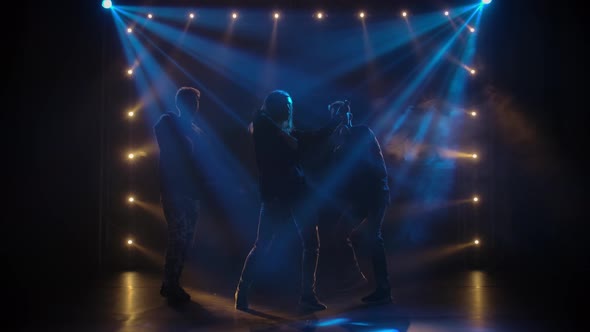 Silhouettes of a Talented Group Young Hip Hop Dancers. Hip Hop Street Dance on a Stage in Dark alt