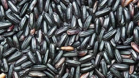 top view of scattered shelled black glutinous rice on the table. abstract food background.