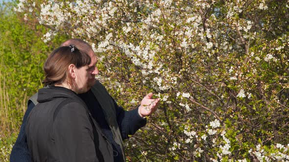 Young woman and man near a flowering tree