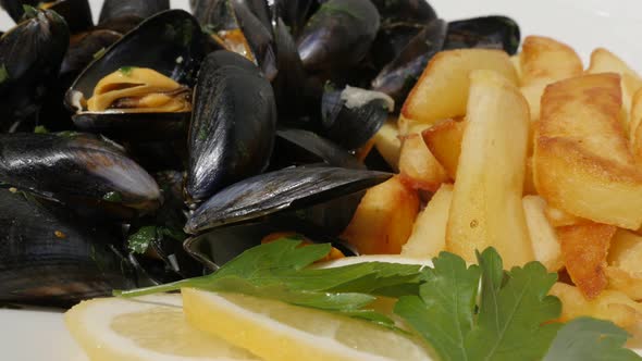 Lot of blue common mussels with french chips  fries and lemon 4K 2160p 30fps UltraHD footage - Slice alt