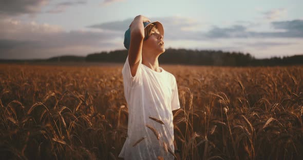 Funny Boy in a Golden Wheat Field Looks at the Beautiful Sky at Sunset Amazing Nature Beautiful