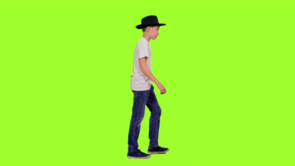 Teenage Boy Walking in White T-shirt and Black Hat
