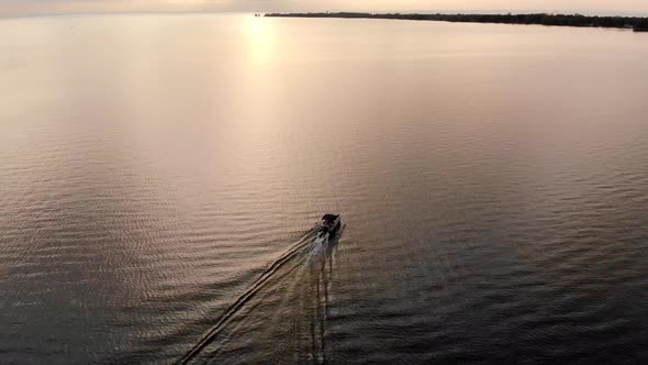 Drone footage of recreational boat cruising on Lake Huron during sunset in Michigan alt